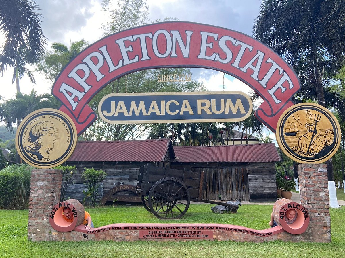 Sign for the Appleton Rum Tour, featuring the logo and information about the distillery's history and rum production process, set against a backdrop of lush Caribbean greenery.