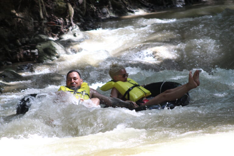Tubers floating down the gentle currents of the White River amidst vibrant greenery